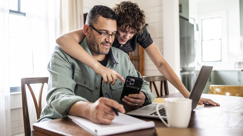 Gamin montrant un homme plus âgé comment utiliser iPhone