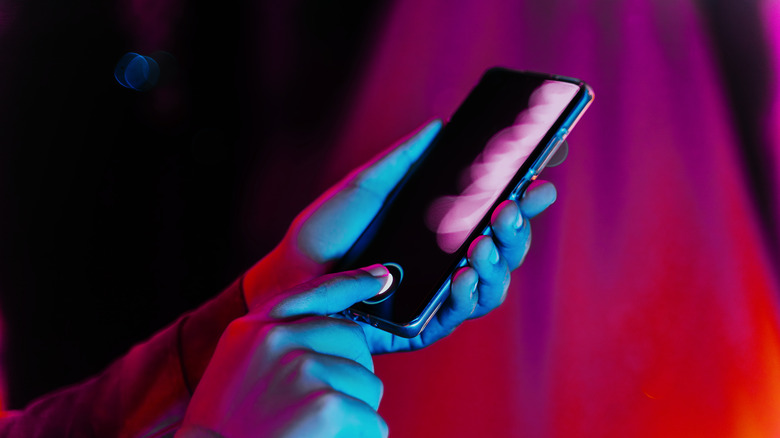 Personne déverrouillant son smartphone à l'aide du scanner d'empreintes digitales