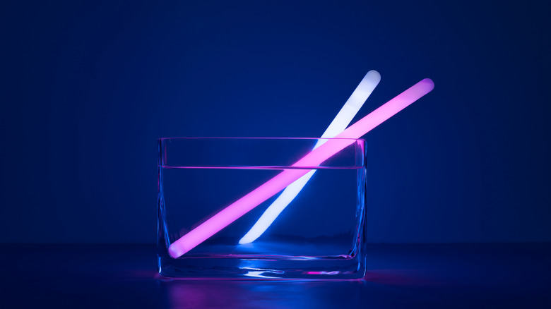 Deux bâtons de lueur reposent dans un récipient en verre