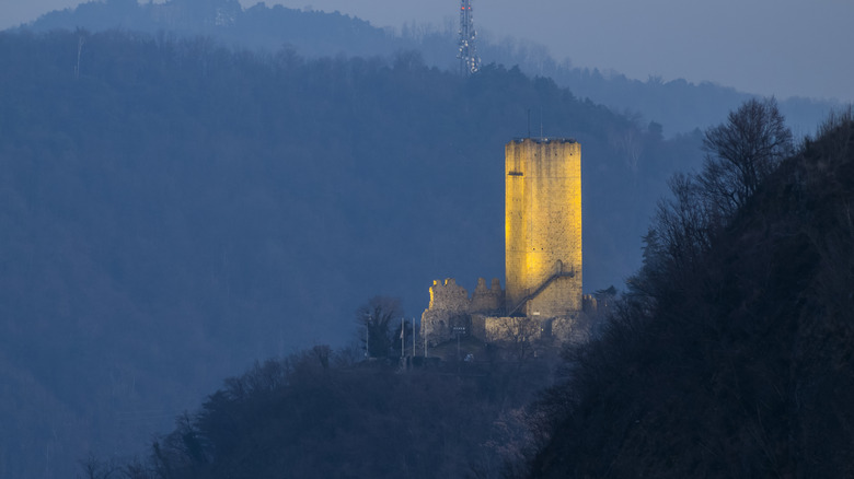 Un paysage d'hiver montre la tour allumée de Castello Baradello dans le nord de l'Italie