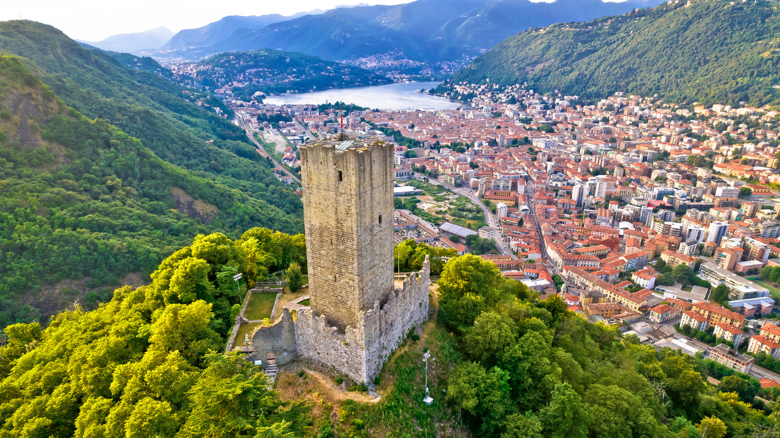 Un beau château historique surplombe le lac éblouissant de l'Italie avec vue sur les Alpes