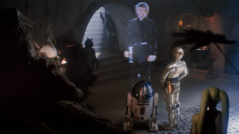 Jabba les Hutt, C-3PO et R2-D2 regardent un message d'hologramme de Luke Skywalker dans Star Wars: Return of the Jedi