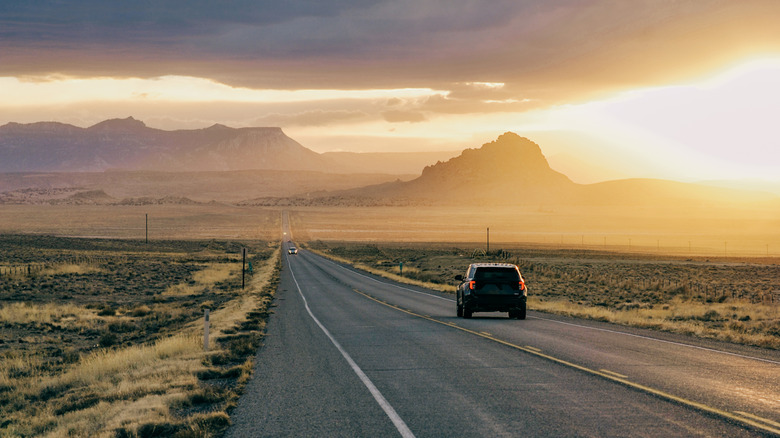 Voiture conduisant sur l'autoroute à travers les plaines poussiéreuses