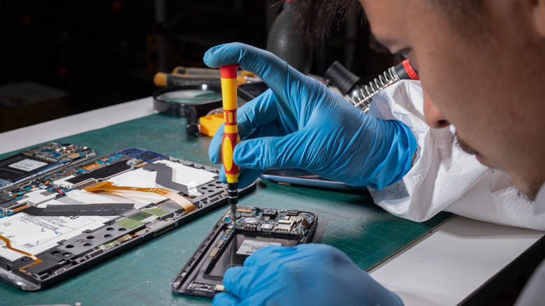 personne réparant un dispositif démonté