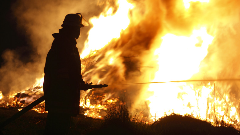 Un pompier combattant un incendie en plein air.