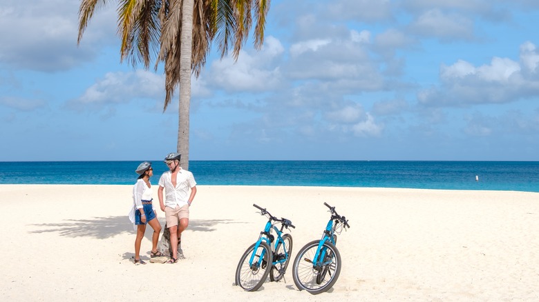 Homme et femme avec des vélos sur la plage