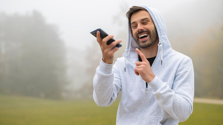 Homme tenant le téléphone à la main pour envoyer un message vocal.