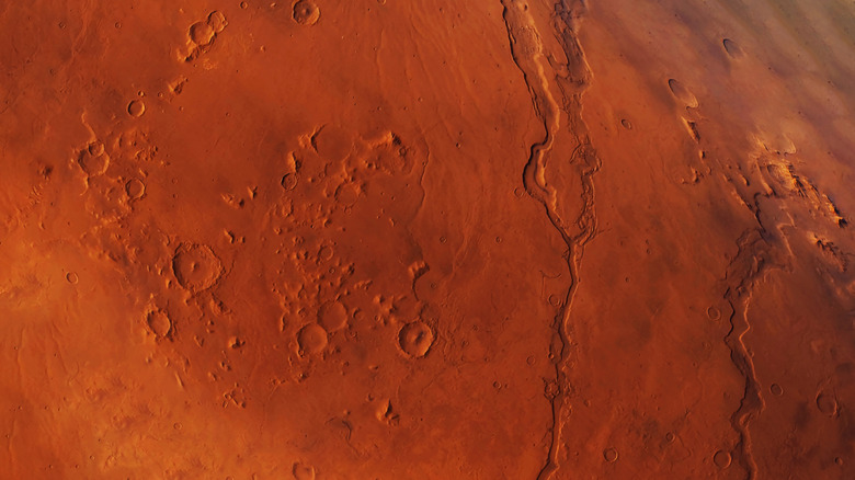 Les cratères et les vallées sont vus dans une vue supérieure à la surface de Mars