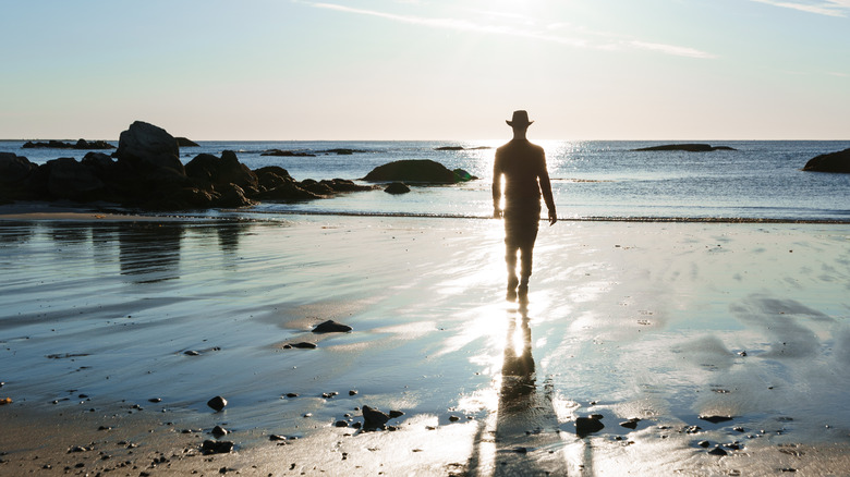 Un homme marche le long du bord de la mer de Kejimkujik