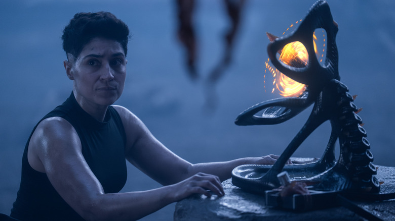 Melissa Navia en tant qu'Ortegas dans Star Trek: Strange New Worlds, semblant inquiet tout en travaillant sur un morceau de machinerie Gorn