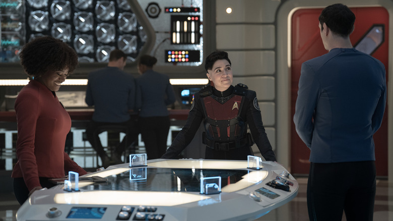 Celia Rose Gooding comme Uhura, Melissa Navia en tant qu'Ortegas et Ethan Peck comme Spock dans la saison 3, épisode 9 de Strange New Worlds, avec Ortegas debout au centre et Uhura riant