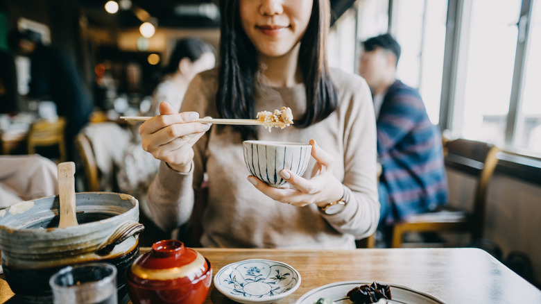 Close Up Fil de jeune femme souriante appréciant la cuisine japonaise