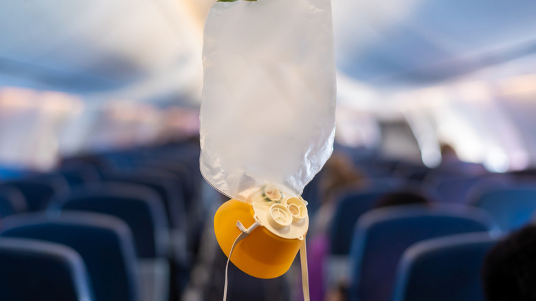 Un masque d'oxygène est suspendu dans la cabine d'un avion