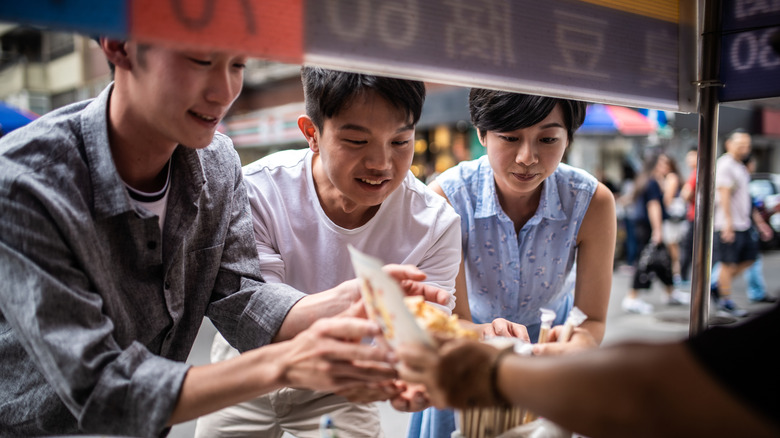 Trois personnes commandaient des confesses Street à un vendeur