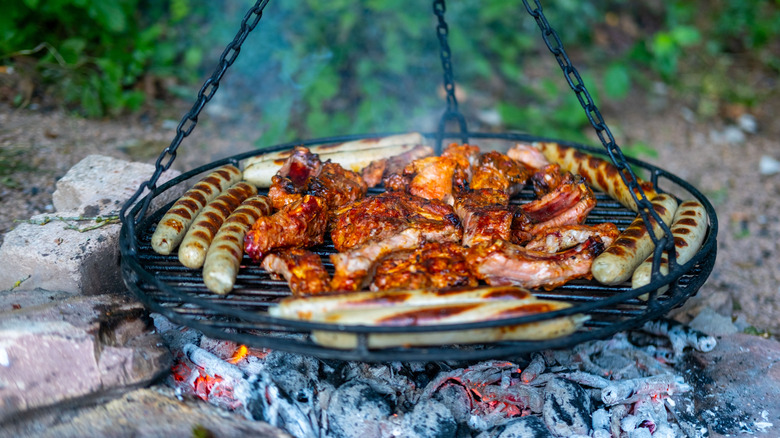 Configuration du campire avec grillade à la viande sur rack de fer