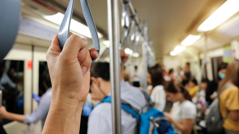 Une main tenant une poignée de voiture de train