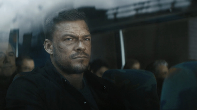Jack Reacher d'Alan Ritchson est vu à travers la fenêtre d'un bus à Reacher