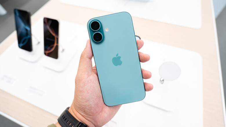 Une personne tenant un iPhone dans un magasin Apple.