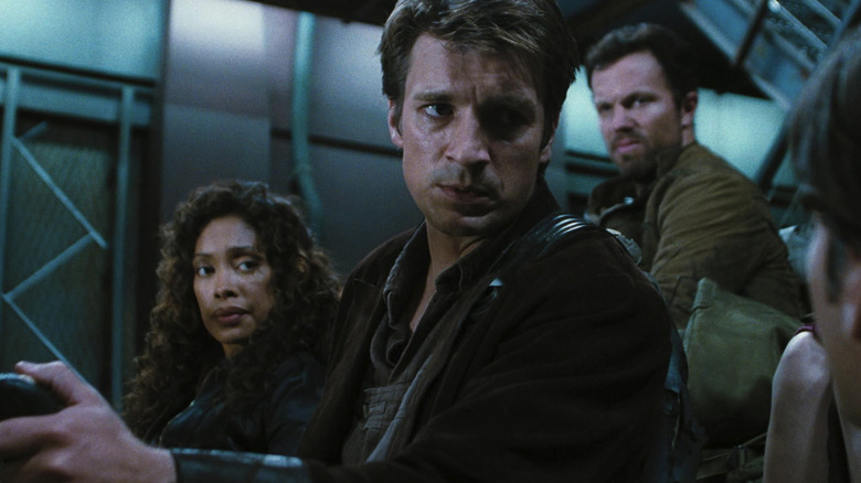 Mal Reynolds, Zoe Washburne et Jayne Cobb sur un navire de transport en regardant quelqu'un de caméra en sérénité