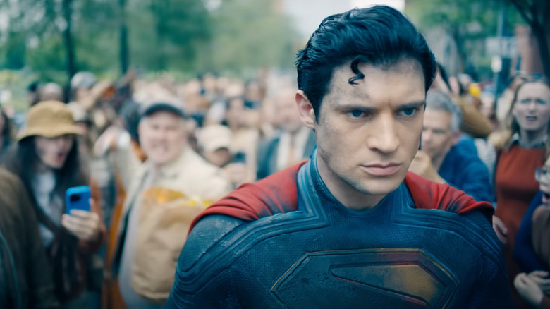David Corenswet en tant que Superman marchant dans une foule en colère à Superman