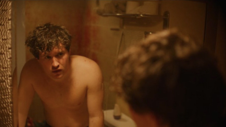 Rohan Campbell en tant que Billy se regardant dans le miroir de la nuit silencieuse, Deadly Night (2025)