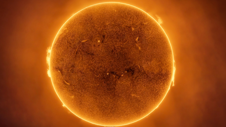 Le soleil est vu orange brillant avec des détails de surface visibles