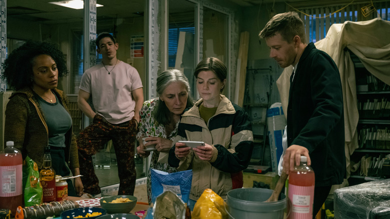 Le gars de Louisa de Rosalind Eleazar, Roddy Ho de Christopher Chung, Catherine Standish de Saskia Reeves, Shirley Dander d'Edwards et de Jack Lowden se tiennent dans leur bureau en chevaux lentes