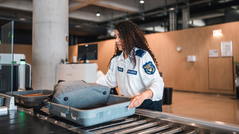 Agent TSA poussant le bac avec des bagages
