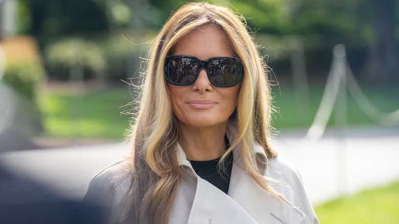 Melania Trump dans un trench blanc et des lunettes de soleil