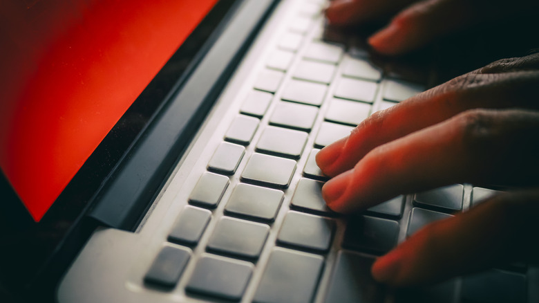 Un pirate informatique fonctionne sur un écran d'ordinateur portable inquiétant.