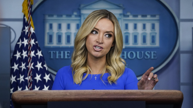 Kayleigh McEnany se tenant sur un podium dans une robe bleue