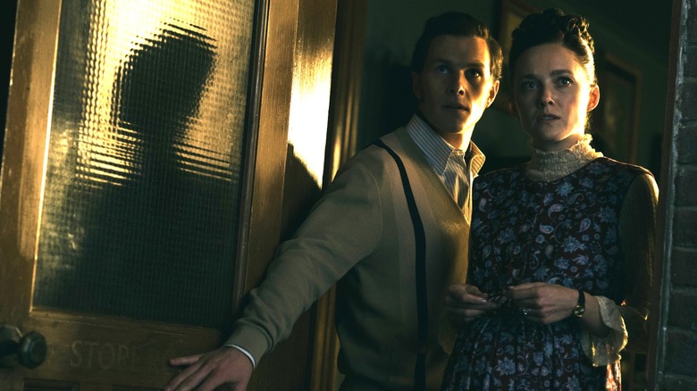 Madison Lawlor en tant que jeune Lorraine Warren et Orion Smith en tant que jeune Ed Warren se tenant près d'une porte ouverte dans la conjuration: Last Rites