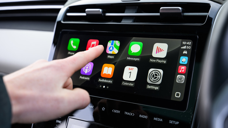 Doigt pointant l'application Carplay Maps