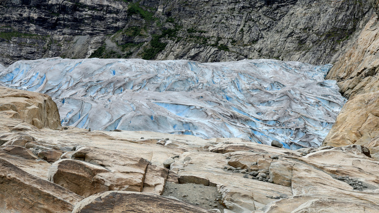 Le glacier jostédal bleu et gris, entouré de rochers