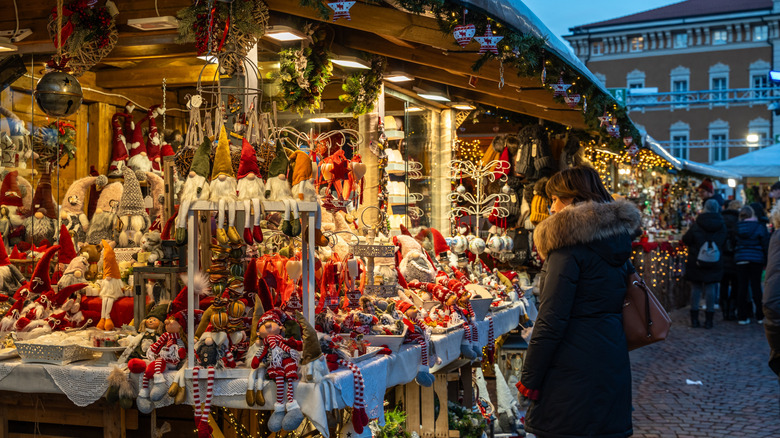 Une femme debout devant un marché de Noël italien.