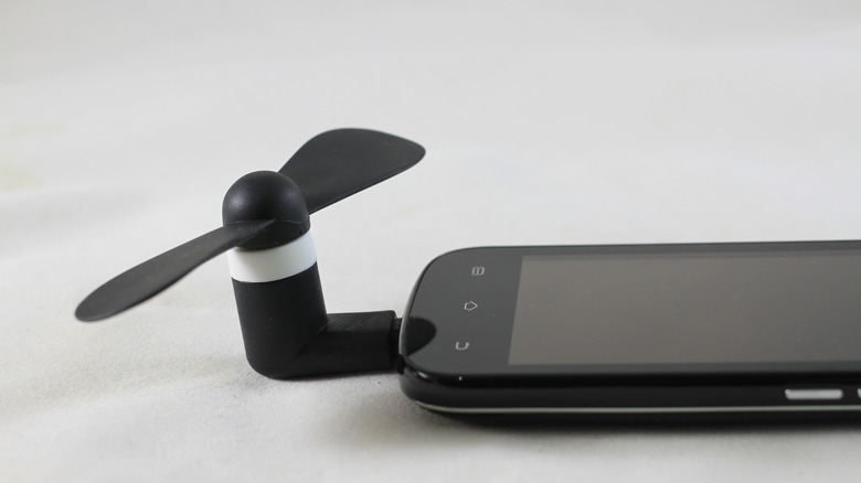 Mini ventilateur USB branché sur le port USB d'un téléphone