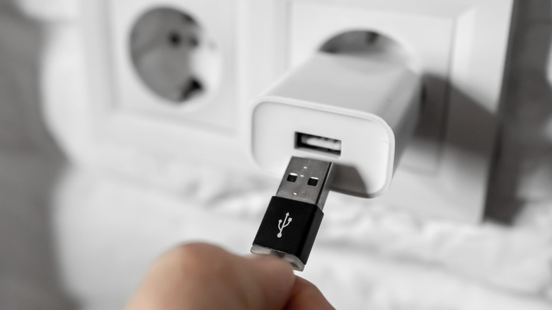 Personne branchant le câble dans une brique de charge