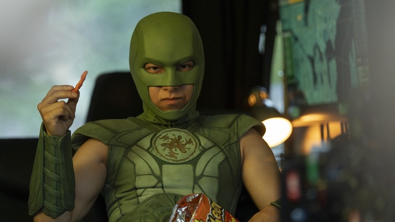 La Judomaster de Nhut Le mange des Cheetos et portant son costume de super-héros sur Peacemaker