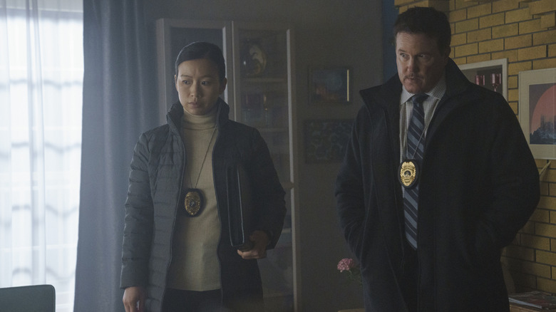 Annie Chang en tant que Sophie Song et Lochlyn Munro que Larry Fitzgibbon se tenant sur une scène de crime dans la saison 1 Peacemaker 1