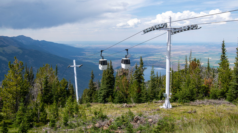Des voitures de gondole à monter une colline, des montagnes à distance