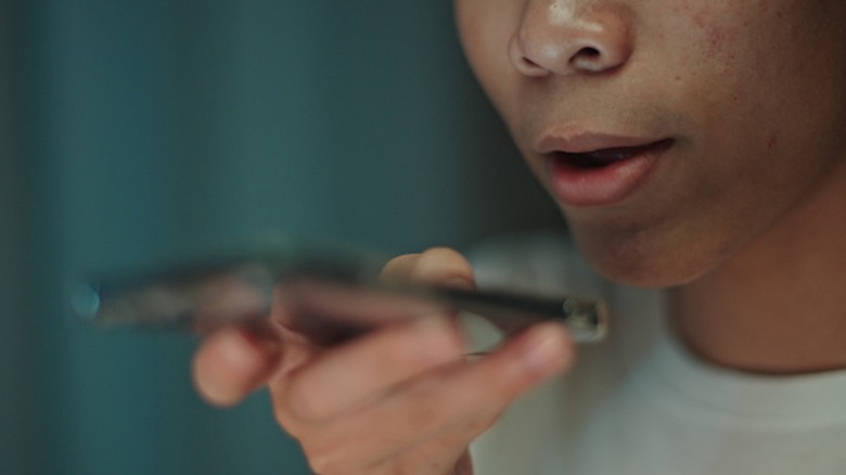 Personne qui parle dans le micro en bas du téléphone