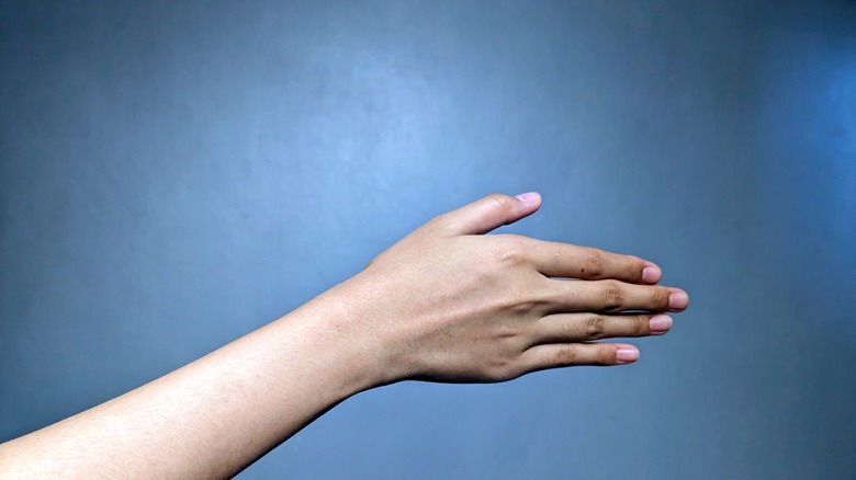 Gros plan de l'avant-bras de la personne sur fond bleu