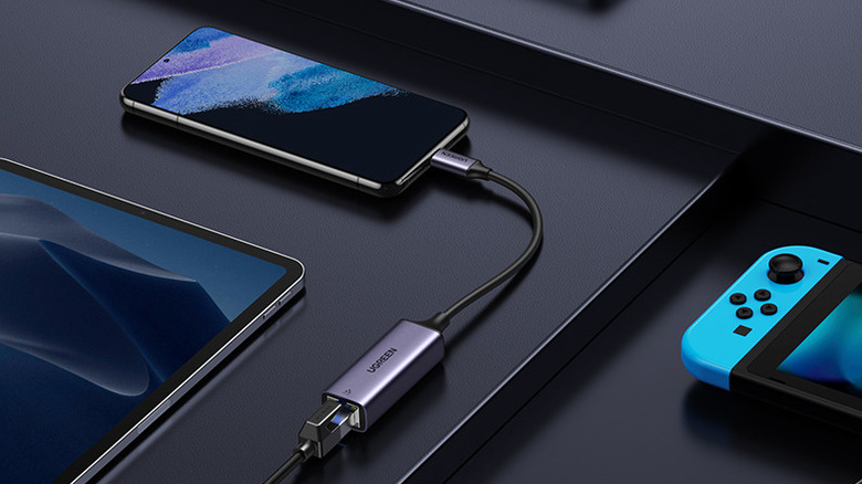 Un câble Ugreen USB-C vers Ethernet connecté à un téléphone.