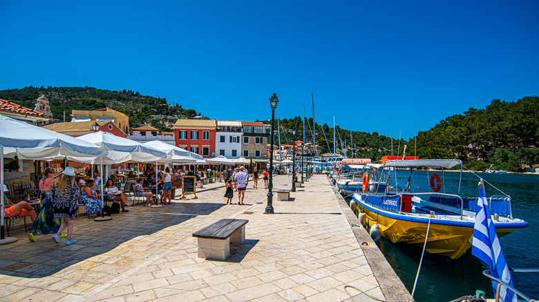 Les gens aux tables du restaurant extérieur au bord de l’eau