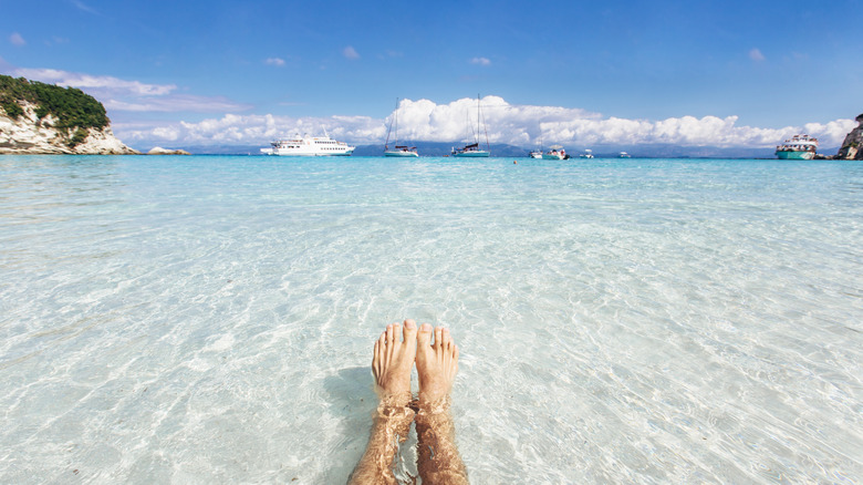 deux pieds flottant sur l'eau cristalline de la plage