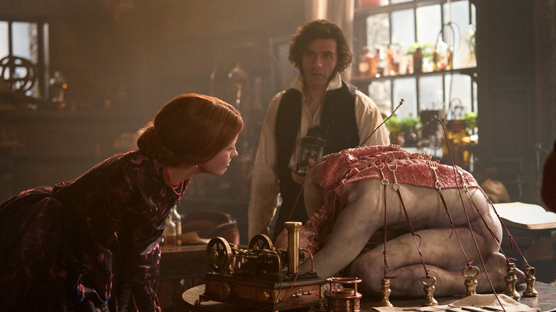 Elizabeth regarde un cadavre disséqué pendant que Victor la regarde dans Frankenstein