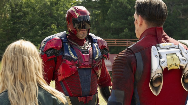 Keith Smith de David Denman portant une armure du capitaine Triumph tout en faisant face à la pacificatrice de John Cena et Emilia Harcourt de Jennifer Holland sur la pacificatrice