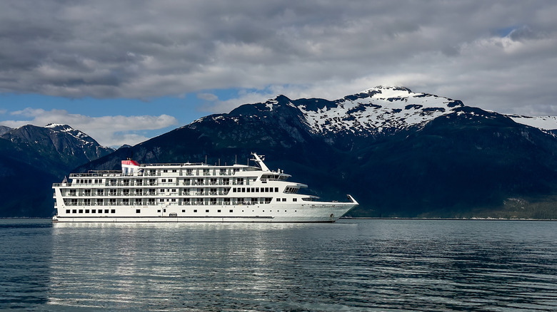 Un petit bateau de croisière devant les montagnes de l'Alaska.