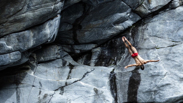 Un homme plonge d'une falaise