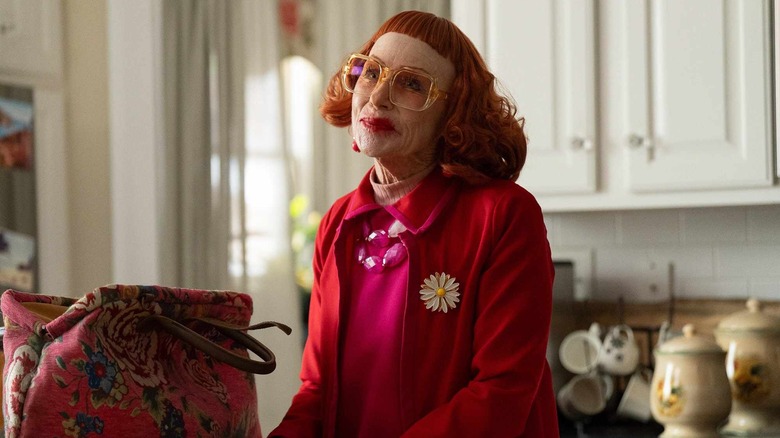 Gladys dans la cuisine de Marcus souriante à côté de son sac à main dans Weapons